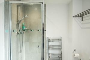 a bathroom with a shower with a glass door at Bucks Luxury Apartment - free parking in Buckinghamshire