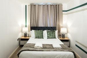 a small bedroom with a bed with two night stands at Bucks Luxury Apartment - free parking in Buckinghamshire