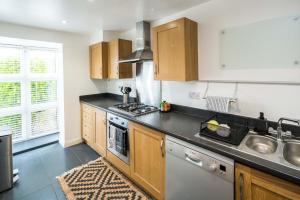 a kitchen with a sink and a stove top oven at Bucks Luxury Apartment - free parking in Buckinghamshire