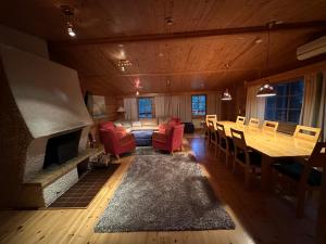 a living room with a fireplace and a table and chairs at Saajopolku 4 in Saariselka