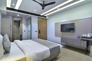 una camera con letto e TV a schermo piatto di International Embassy Suites a Nuova Delhi