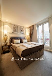 a bedroom with a large bed and a window at LES PERLES AMIENOISES✩BLACK PEARL☆HYPER CENTRE☆ in Amiens