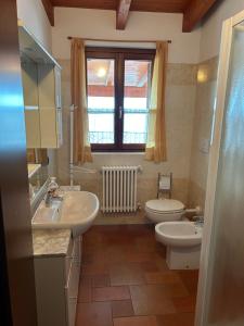 łazienka z 2 umywalkami, toaletą i oknem w obiekcie Casa del Sole w mieście Dorio