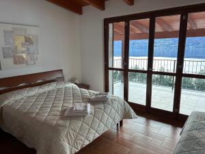sypialnia z łóżkiem i dużymi szklanymi drzwiami w obiekcie Casa del Sole w mieście Dorio