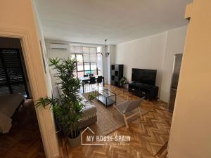 a living room with a couch and a tv at MyHouseSpain - Maravilloso apartamento renovado in Madrid