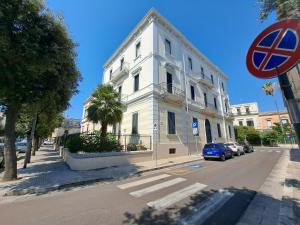 um edifício branco ao lado de uma rua em iLCastellano - Suites & Apartments em Lecce