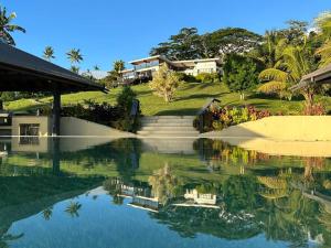 にあるGreen Fiji Plantation Villa in Taveuniの水面の家の反射