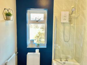 a bathroom with a shower and a toilet and a window at Summer Lane House-3 Bedrooms-Close to M1-Longer Stay-Free Parking in Barnsley +28 photos