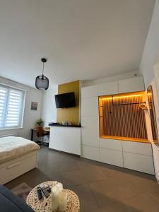 a living room with a bed and a kitchen at Escapade - Studio cosy au centre de Saint-Omer in Saint-Omer
