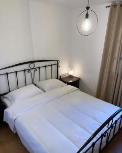 a bedroom with a large white bed and a lamp at Nereid Skyros House in Skiros