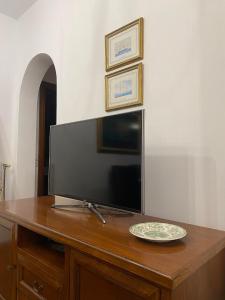 a television on a wooden table with a plate on it at Nereid Skyros House in Skiros