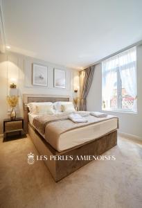 a bedroom with a large bed and a large window at LES PERLES AMIÉNOISES ☆ WHITE PEARL ☆ HYPER CENTRE ☆ in Amiens