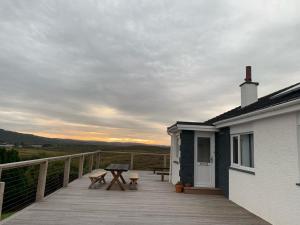 a deck with a table and chairs on a house at Hillview Portree Isle of Skye Self Catering House in Portree