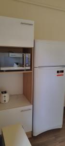 uma cozinha com um frigorífico branco e um micro-ondas em Stadion Apartman em Eger