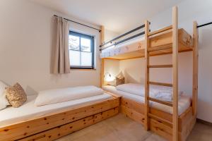 a bedroom with two bunk beds and a window at Chalet Charlotte in Niedernsill