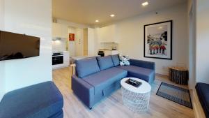 a living room with a blue couch and a tv at Lakefront Oasis by Harmony Whistler in Whistler