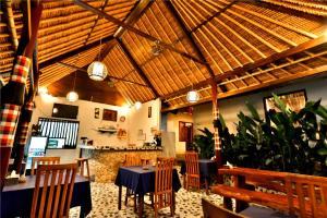 倫邦岸島的住宿－藍夢島日落酒店，餐厅设有桌椅和木制天花板。