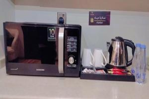 een magnetron op een aanrecht met een koffiepot bij Marbella Residential Units in Riyad