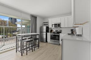 a kitchen with stainless steel appliances and a balcony at Fin's Inn in Myrtle Beach