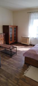 um quarto com uma cama, uma mesa e uma janela em Stadion Apartman em Eger