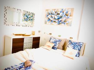 Luxury Bahia Sea Views By Deihu Experiences في لوس كريستيانوس: غرفة نوم مع سرير ووسائد زرقاء وبيضاء