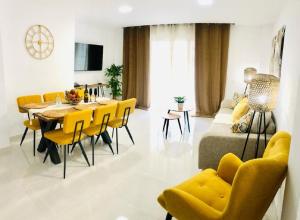 Luxury Bahia Sea Views By Deihu Experiences في لوس كريستيانوس: غرفة معيشة مع طاولة وكراسي صفراء