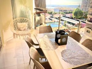 Luxury Bahia Sea Views By Deihu Experiences في لوس كريستيانوس: غرفة طعام مع طاولة وكراسي وشرفة