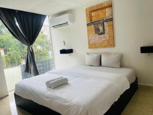 a bedroom with a large white bed with a window at Gorgona Beach House in Nueva Gorgona