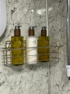 three perfume bottles on a shelf in a bathroom at Duirinish Pods with Private Hot Tubs and Duirinish Bothy with No Hot Tub in Plockton
