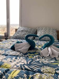 uma cama com duas serpentes de toalha sentadas nela em Studio avec vue sur le lac jardin clos et wifi a Conflans Sainte Honorine em Conflans-Sainte-Honorine