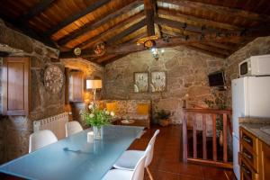kuchnia ze stołem i krzesłami w pokoju w obiekcie Casa Do Charco - Peneda Gerês w mieście Geres