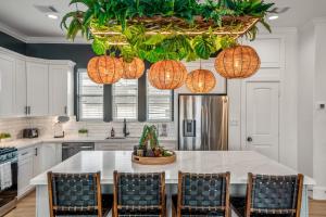 cocina con mesa con sillas y luces colgantes en The Green Haus: Luxxe Cabana Rooftop Retreat, en Houston