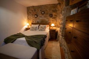 sypialnia z łóżkiem i komodą z 2 lampami w obiekcie Casa Do Sertão - Gerês w mieście Geres