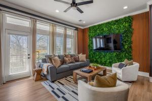sala de estar con sofá y TV en The Green Haus: Luxxe Cabana Rooftop Retreat, en Houston