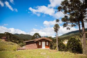 una pequeña casa en una colina en un campo en Recanto das Águas - Urubici - SC, en Urubici