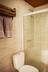 a bathroom with a toilet and a glass shower at Recanto das Águas - Urubici - SC in Urubici