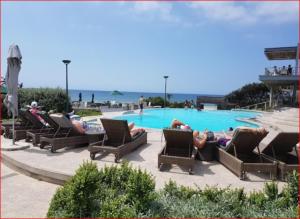 a group of people laying in chairs by a swimming pool at Zimbali Suite 107 in Ballito