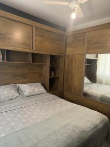 a bedroom with two beds and a ceiling fan at Serra Mar Suítes,Lofts, e casas à 300 metros das praias in Arraial do Cabo