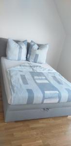 uma cama com lençóis e almofadas azuis e brancos em Living in a penthouse in Frankfurt, with balcony for smokers em Frankfurt