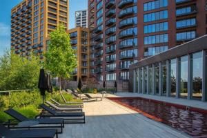a patio with chairs and a pool in front of a building at Luxury & Spacious 2 BR APT with City Views in London