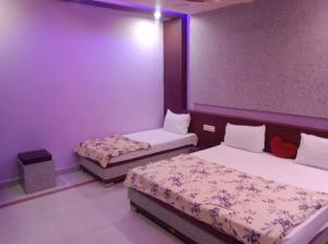 Sītāpur MūāfiにあるHotel Parvati Residencyの紫の壁のドミトリールーム ベッド2台