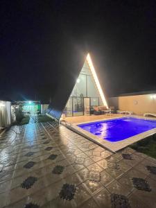 - une piscine éclairée la nuit dans un bâtiment dans l'établissement Gabala Twin A Frame Villas, à Qabala