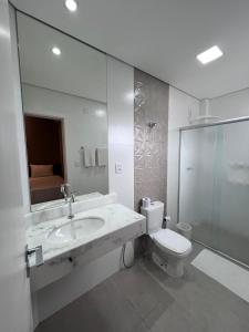 a bathroom with a sink and a toilet and a mirror at Regis Hotel II in Registro +30 photos
