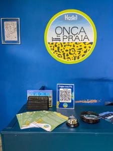 uma mesa azul com um sinal numa parede azul em Onça da Praia Hostel em Vitória