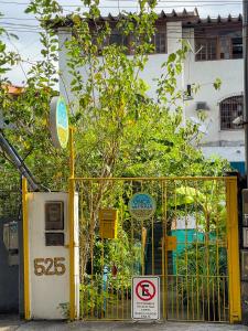 un cancello giallo senza insegna di parcheggio di fronte a un edificio di Onça da Praia Hostel a Vitória