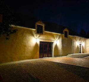 a building with lights on the side of it at night at La Perchonniere in Mamers