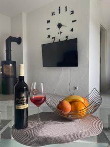 a bottle of wine next to a bowl of fruit and a glass at FeWo Giss in Postbauer-Heng