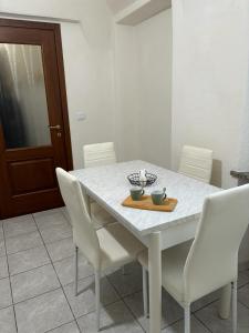 a dining room table with white chairs and a white counter top at Zoe Recidencias 3 in Boves