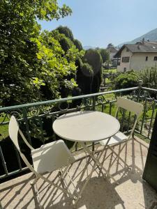 uma mesa branca e 2 cadeiras numa varanda em Appartement 1er étage Villa Isabelle em Allevard