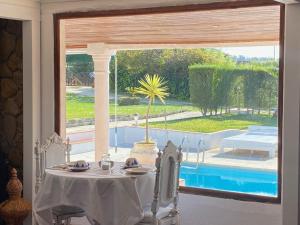 a table in a room with a view of a pool at Vinha da Quinta in Sintra